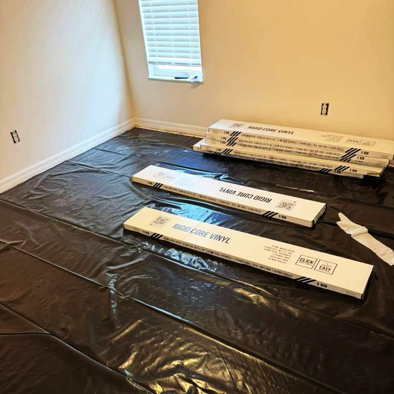 Vinyl Flooring Installation Preparation with Moisture Barrier Room prepared for vinyl flooring installation with moisture barrier and vinyl planks ready