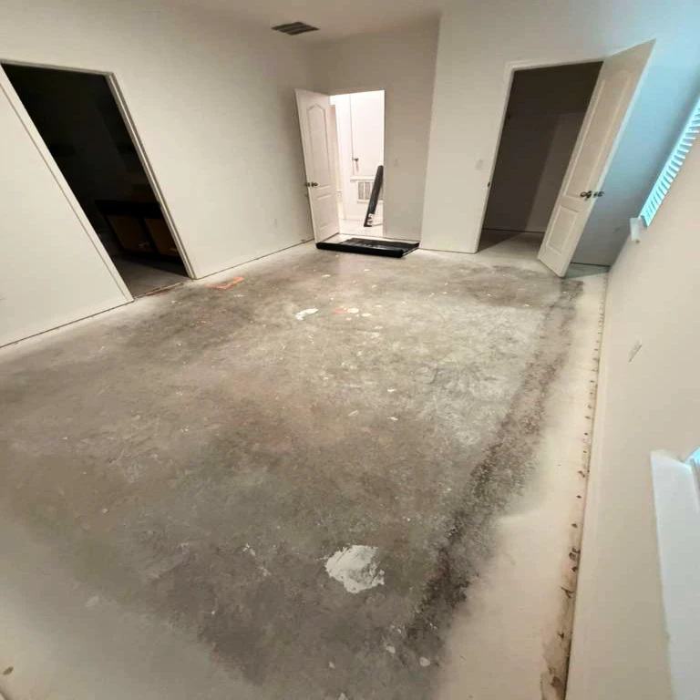 Before Flooring Installation — Master Bedroom Subfloor | PSL Floor & Supply Master bedroom before flooring installation — large concrete subfloor with staining and adhesive residue, Port St. Lucie home by PSL Floor & Supply