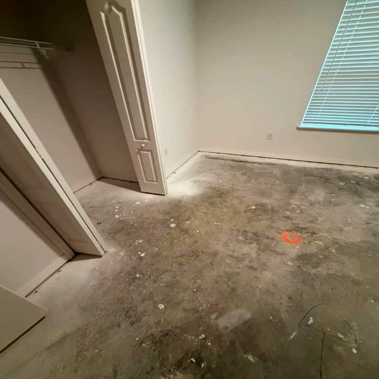 Before Flooring Installation — Bedroom Subfloor | PSL Floor & Supply Bedroom before flooring installation — concrete subfloor with debris and adhesive residue, Port St. Lucie home by PSL Floor & Supply